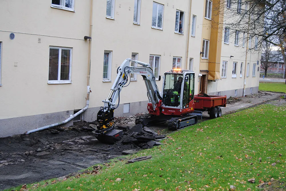 Grävmaskin utför dräneringsarbete vid flerbostadshus i Göteborg – Lerbergs Entreprenad